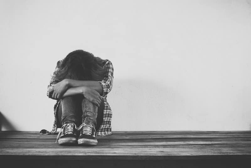 Girl with her head down in her lap